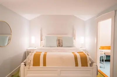 a white bedroom with a large bed in a room at Boisé Rivière in Bolton-Est