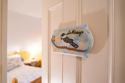 a sign on a door with a bird on it at Boisé Rivière in Bolton-Est
