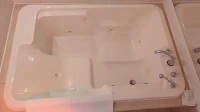 a white bath tub with a faucet in a bathroom at Hotel Motel Granby in Granby