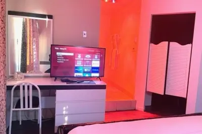 a desk with a computer on it in a bedroom at Hotel Motel Granby in Granby