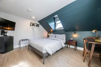 a bedroom with a bed and a blue ceiling at Square Victoria Maison Hôtelière in East Angus