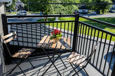 a wooden table with flowers on a balcony at Square Victoria Maison Hôtelière in East Angus