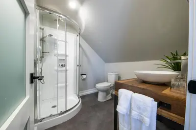 a bathroom with a shower and a toilet and a sink at Square Victoria Maison Hôtelière in East Angus