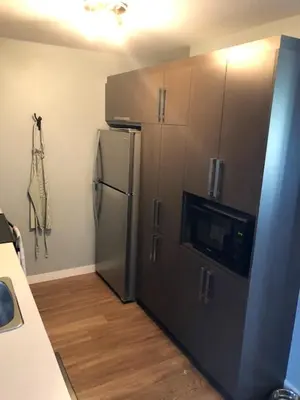 a kitchen with a stainless steel refrigerator and cabinets at Luxurious Apartment in Brossard with Terrace in Brossard