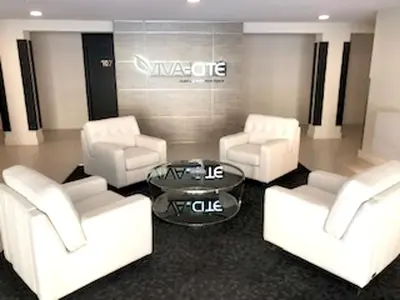 a living room with white chairs and a table at Luxurious Apartment in Brossard with Terrace in Brossard