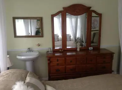 a bedroom with a sink and a dresser with a mirror at Maison Parc Delormier in Trois-Rivières