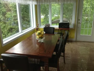 a dining room table with a bowl of fruit on it at Maison Parc Delormier in Trois-Rivières