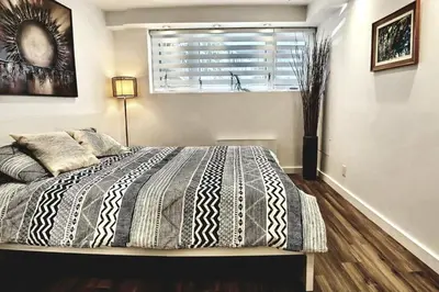 a bedroom with a large bed with a window and a window at Cosy apartment at Bossuet road in Montréal