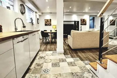 a kitchen and living room with a couch and a table at Cosy apartment at Bossuet road in Montréal