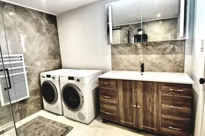 a laundry room with a washer and dryer and a sink at Cosy apartment at Bossuet road in Montréal