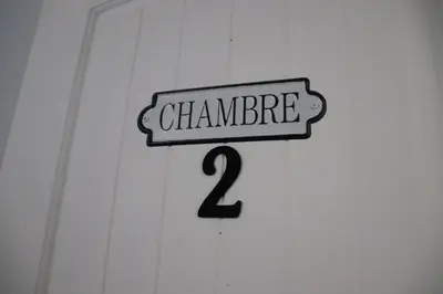 a sign that reads chambre on a white door at Casa Linda Victoriaville in Princeville