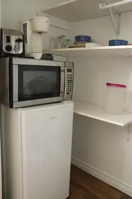 a microwave on top of a refrigerator in a kitchen at Casa Linda Victoriaville in Princeville
