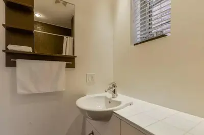 a white bathroom with a sink and a window at Le Duplex VIP in Montréal