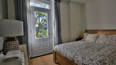 a bedroom with a bed and a door with a window at Le Duplex VIP in Montréal
