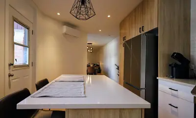 a kitchen with a table and a refrigerator at Le Duplex VIP in Montréal