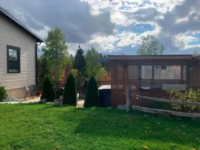 a backyard of a house with a shed at La Spacieuse Riverstone CITQ3O1849 in Saint Pierre de Broughton