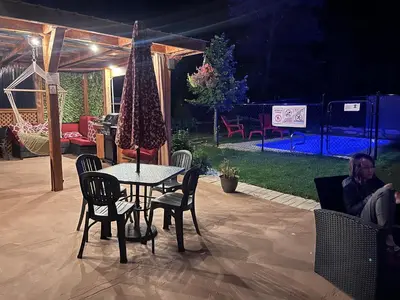 a table and chairs in a patio with a tent at La Spacieuse Riverstone CITQ3O1849 in Saint Pierre de Broughton