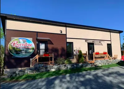 a building with a restaurant sign on the side of it at La Spacieuse Riverstone CITQ3O1849 in Saint Pierre de Broughton