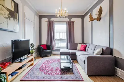 a living room with a couch and a tv at MtlVacationRentals - Appartements Plateau-Mont-Royal in Montréal