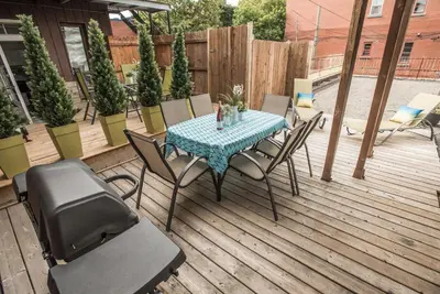 a patio with a table and chairs on a deck at MtlVacationRentals - Appartements Plateau-Mont-Royal in Montréal