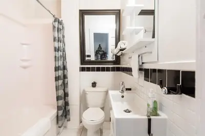 a bathroom with a toilet and a sink and a mirror at MtlVacationRentals - Appartements Plateau-Mont-Royal in Montréal