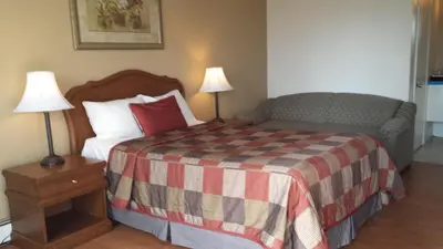 a bedroom with a bed and two lamps on tables at Motel Iberville in Saint-Jean-sur-Richelieu