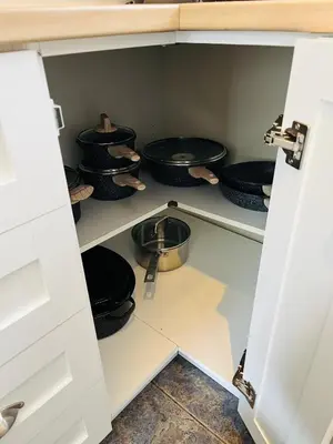 a cupboard filled with black pots and pans at Le Jackrabbit Orford Domaine Cheribourg in Orford