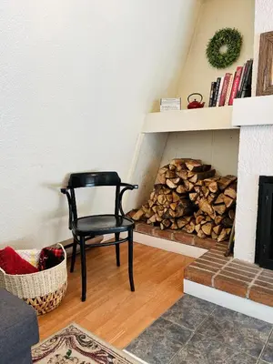 a black chair in a living room with a fire place at Le Jackrabbit Orford Domaine Cheribourg in Orford