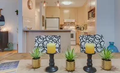 a kitchen with a table with two chairs and two candles at Condo Entre Ville et Nature 2 in Magog-Orford