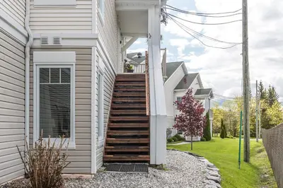 a house with stairs on the side of it at Condo Entre Ville et Nature 2 in Magog-Orford