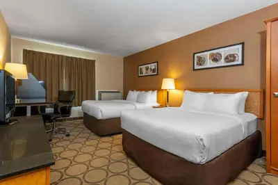 a hotel room with two beds and a television at Comfort Inn Thetford Mines in Thetford Mines