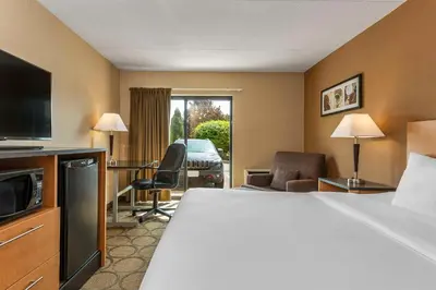 a hotel room with a bed and a desk and a television at Comfort Inn Thetford Mines in Thetford Mines