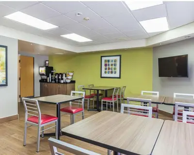 a dining room with tables and chairs and a flat screen tv at Comfort Inn Thetford Mines in Thetford Mines