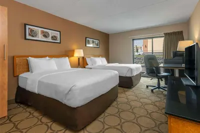 a hotel room with two beds and a television at Comfort Inn Thetford Mines in Thetford Mines