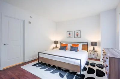 a bedroom with a large bed with orange pillows at Le Mille Neuf Apartments Modern Comfort in Downtown Montreal in Montréal