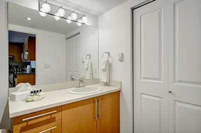 a bathroom with a sink and a mirror at Le Mille Neuf Apartments Modern Comfort in Downtown Montreal in Montréal