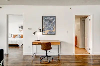 a home office with a desk and a bed at Le Mille Neuf Apartments Modern Comfort in Downtown Montreal in Montréal