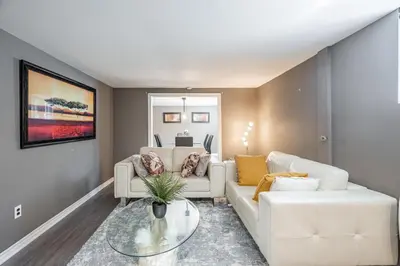 a living room with two white couches and a table at Appart SS avec bain tourbillon CITQ 3I8I25 in Mascouche