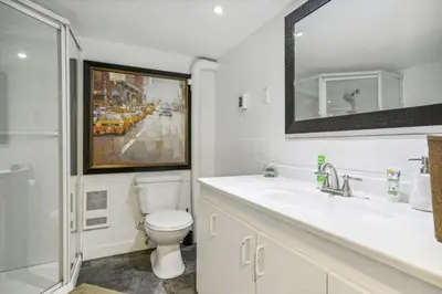 a bathroom with a toilet and a sink and a mirror at Appart SS avec bain tourbillon CITQ 3I8I25 in Mascouche