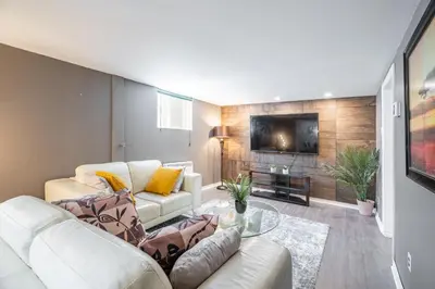 a living room with a couch and a tv at Appart SS avec bain tourbillon CITQ 3I8I25 in Mascouche