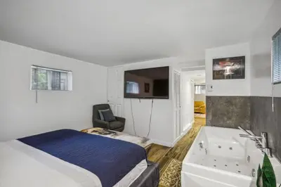 a bedroom with a bed and a tub and a sink at Appart SS avec bain tourbillon CITQ 3I8I25 in Mascouche