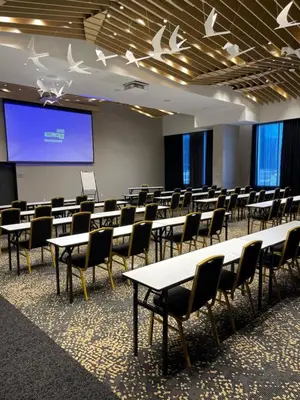 a room with tables and chairs and a projection screen at Courtyard by Marriott Montreal Brossard in Brossard