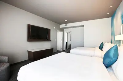 a hotel room with two beds and a flat screen tv at Courtyard by Marriott Montreal Brossard in Brossard