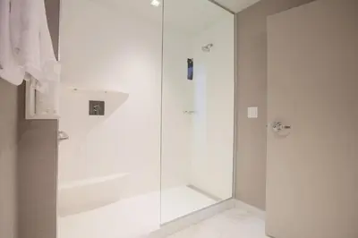 a shower with a glass door in a bathroom at Courtyard by Marriott Montreal Brossard in Brossard
