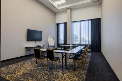 a conference room with a table and chairs and a tv at Courtyard by Marriott Montreal Brossard in Brossard