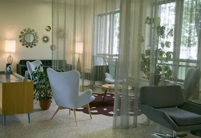 a living room with white chairs and a table at Manoir d'Youville in Châteauguay Heights