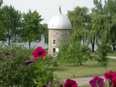 a building with a dome on top of a field at Manoir d'Youville in Châteauguay Heights