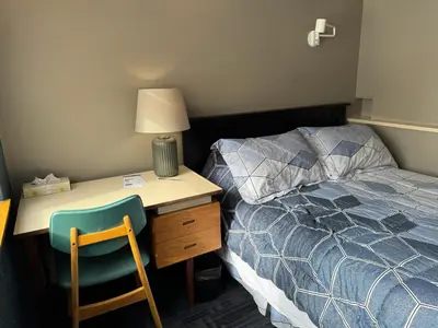 a bedroom with a bed and a desk and a bed sidx sidx sidx at Manoir d'Youville in Châteauguay Heights