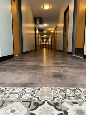 an empty hallway of an office building with a tile floor at Manoir d'Youville in Châteauguay Heights