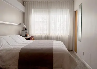 a bedroom with a large bed and a window at Manoir d'Youville in Châteauguay Heights